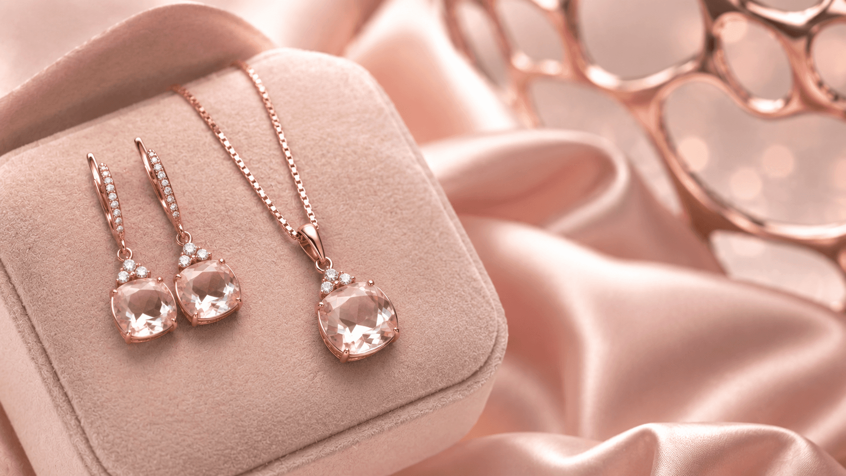 Rose-tone fashion jewellery pendant and earring set styled on blush satin